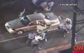 The video shows more than a dozen officers dragging the suspects from their car and pummeling them