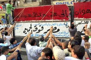 Protesters tear down a concrete wall protecting Israel's embassy in Cairo